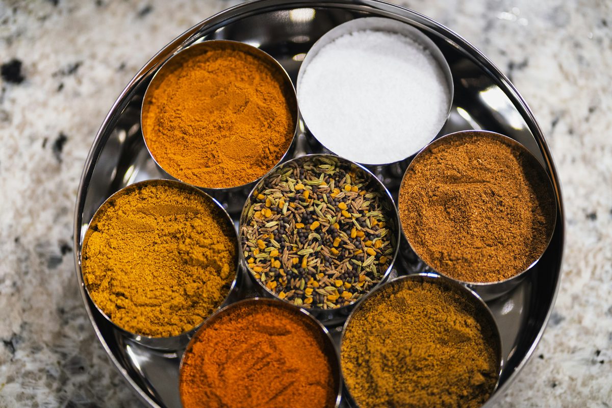 A masala dabba with whole and ground spices